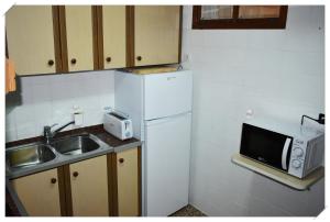 a small kitchen with a sink and a refrigerator at Sol y mar a la playa in Puerto de Mazarrón