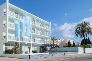 a white apartment building with blue flags in front of it at azuLine Hotel Pacific in San Antonio