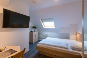 Schlafzimmer mit einem Bett und einem Flachbild-TV in der Unterkunft Hotel intakt in Bedburg
