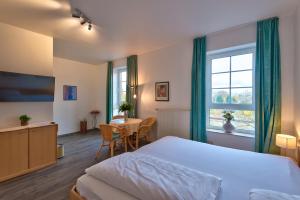 Schlafzimmer mit einem Bett, einem Tisch und einem Fenster in der Unterkunft Hotel intakt in Bedburg