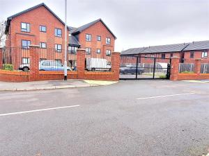 een lege parkeerplaats voor een bakstenen gebouw bij Manchester Holiday Apartment in Manchester