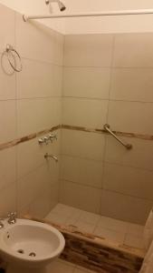 y baño con ducha, lavabo y aseo. en Departamentos Capurro en Mar del Plata