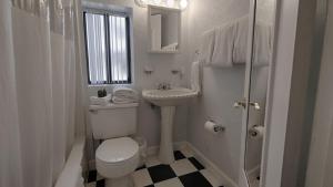 een witte badkamer met een toilet en een wastafel bij Sabal Palms Inn in St Pete Beach