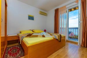 a bedroom with a bed and a large window at Vacattio apartment 2 in Crikvenica