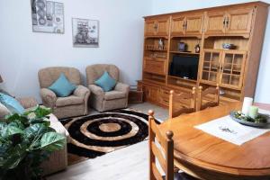uma sala de estar com uma mesa, um sofá e uma televisão em VillaHouse em São Vicente