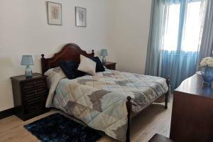 um quarto com uma cama, uma cómoda e uma janela em VillaHouse em São Vicente