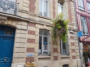 - un bâtiment en briques avec une porte et des fenêtres bleues dans l'établissement Centre historique l'authentique Saint Nicolas ou le bourdon de la Cathédrale, à Rouen