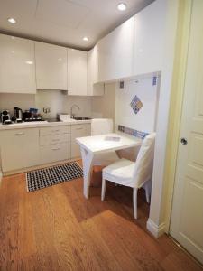 a kitchen with a table, chairs and a refrigerator at Royal Suite Trinità Dei Monti in Rome