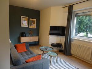 uma sala de estar com um sofá e uma televisão em La vie est Belle em Sélestat