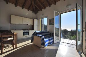 a bedroom with a bed and a kitchen with a balcony at Villa Del Mare Ligure Elvezia in Santo Stefano al Mare