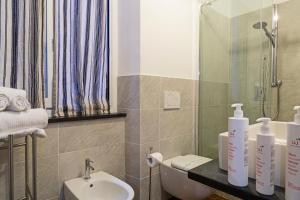 a bathroom with a sink and a toilet and a mirror at La Dimora del Ducale by Wonderful Italy in Genoa
