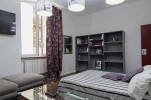 a bedroom with a bed and a couch and a window at La Dimora del Ducale by Wonderful Italy in Genoa
