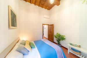 ein Schlafzimmer mit einem blauen Bett und einer Pflanze in der Unterkunft Little Gem in the city center in Florenz