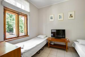 a living room with a couch and a tv and a table at Riga Academic Guest House in Riga