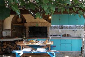 cocina con armarios azules y mesa de madera en Casa Sadde, en Padru