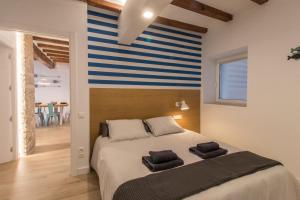 een slaapkamer met een bed met een blauwe en witte streepmuur bij El Mariner in Sant Carles de la Ràpita
