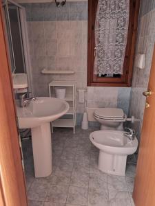 a bathroom with two sinks and a toilet in it at Bilocale vista mare - C6 in Rena Majore