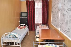 Habitación pequeña con 2 literas y mesa. en Grechesky-15 Guest house, en San Petersburgo
