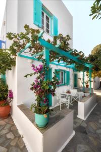 Una casa con puertas azules y flores. en Aegean Village, en Parikia