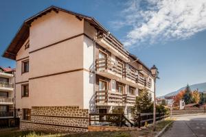 a building with wooden balconies on the side of it at Green Lime Studio in Bansko