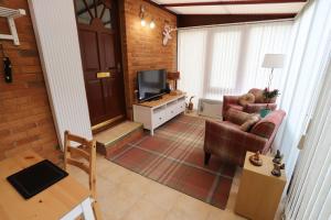 a living room with two chairs and a television at Tweedbank in Galashiels