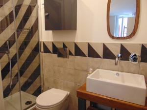 bagno con lavandino, servizi igienici e specchio di Design Studio Flat with Terrace Next Toledo Metro Stop a Napoli