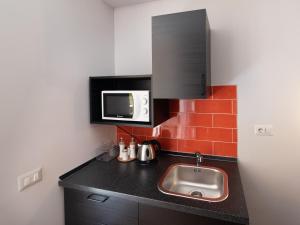 una piccola cucina con lavandino e forno a microonde di Design Studio Flat with Terrace Next Toledo Metro Stop a Napoli