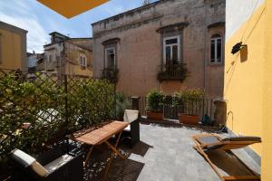 un patio con panca in legno e un edificio di Design Studio Flat with Terrace Next Toledo Metro Stop a Napoli