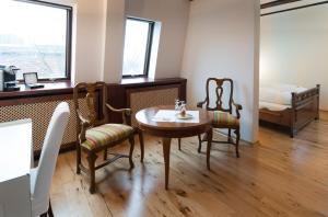 a room with a table and two chairs and a bed at Hotel Ochsen Post in Tiefenbronn