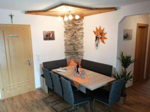 a dining room with a wooden table and chairs at Apart Almrausch in Nauders