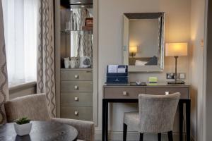 a hotel room with a desk and a mirror at Crown & Mitre Hotel in Carlisle