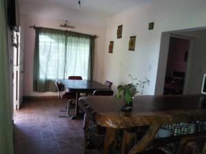 sala de estar con mesa, sillas y ventana en Cabaña Luna de Pueblo en Salta
