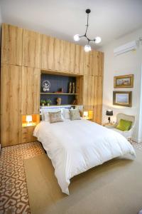 a bedroom with a large white bed and wooden walls at A ESCONDIDASs in Ayamonte