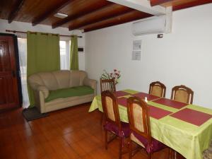a dining room with a table and a couch at Hostal Plaza Maule Express in Talca