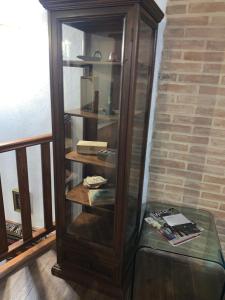 a wooden cabinet with a glass shelf in a room at Antica Potecarìa in Tonara