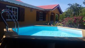 a swimming pool in front of a house at VILLA KAYOU in Deshaies