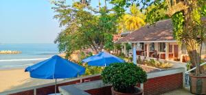 two blue umbrellas sitting next to a beach at Bunga Ayu Seaside Resort in Pelabuhan Ratu