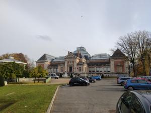 a large building with cars parked in a parking lot at Résidence MUSEE-HOME - Centre ville Valenciennes in Valenciennes