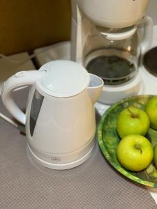una olla blanca en un mostrador con un plato de manzanas en Myllykoski apart, en Ummeljoki