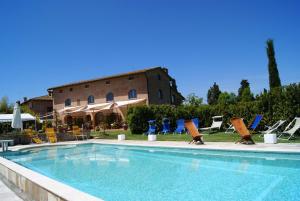 a swimming pool with lounge chairs and a building at Casavacanze Casalta in Sovicille