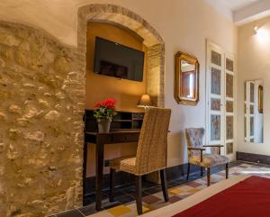 a living room with a table and chairs and a tv at Cappuccine GuestHouse in Cagliari