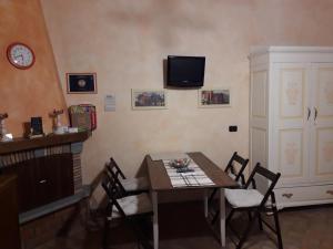 白露里治奧的住宿－Civita Nova，一间设有桌子和墙上电视的用餐室