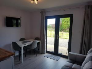 a living room with a table and a sliding glass door at Portglenone Garden Rooms in Portglenone