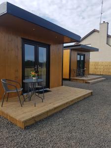 a wooden deck with a table and chairs on a house at Portglenone Garden Rooms in Portglenone