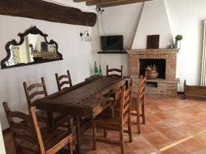 uma sala de jantar com uma mesa de madeira e uma lareira em La Casina em Dello