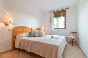 a bedroom with a bed with white sheets and a window at Empurialola -Apartamento vistas mar Empuriabrava-162 in Empuriabrava