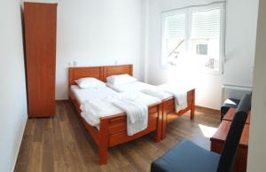 a bedroom with a bed with white sheets and a window at Vaš Kutak 2026 - Sobe Lux za izdavanje in Obrenovac