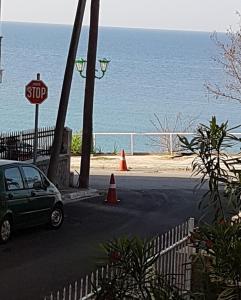 una señal de stop y un coche estacionado junto al océano en Grcka-Reni Greece Beach 2, en Nea Kalikratia