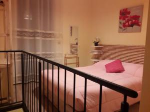 a bedroom with a bed with a pink pillow at Bella Civita in Bagnoregio