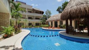 ein Pool neben einem Gebäude mit einem Resort in der Unterkunft Stunning Penthouse with Private Rooftop in Aldea Zama in Tulum